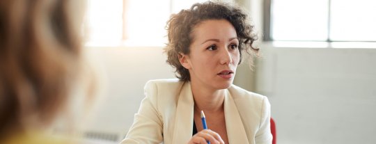 Woman discussing redundancy pay with employees