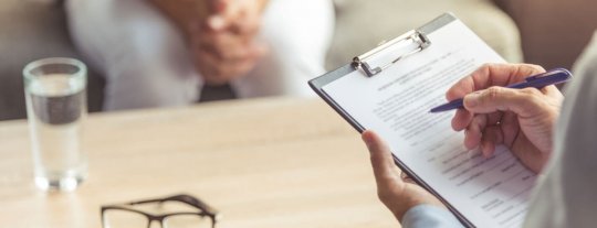 Person writing on a form