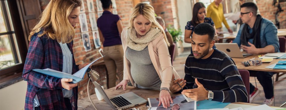 Pregnant lady at work with colleagues