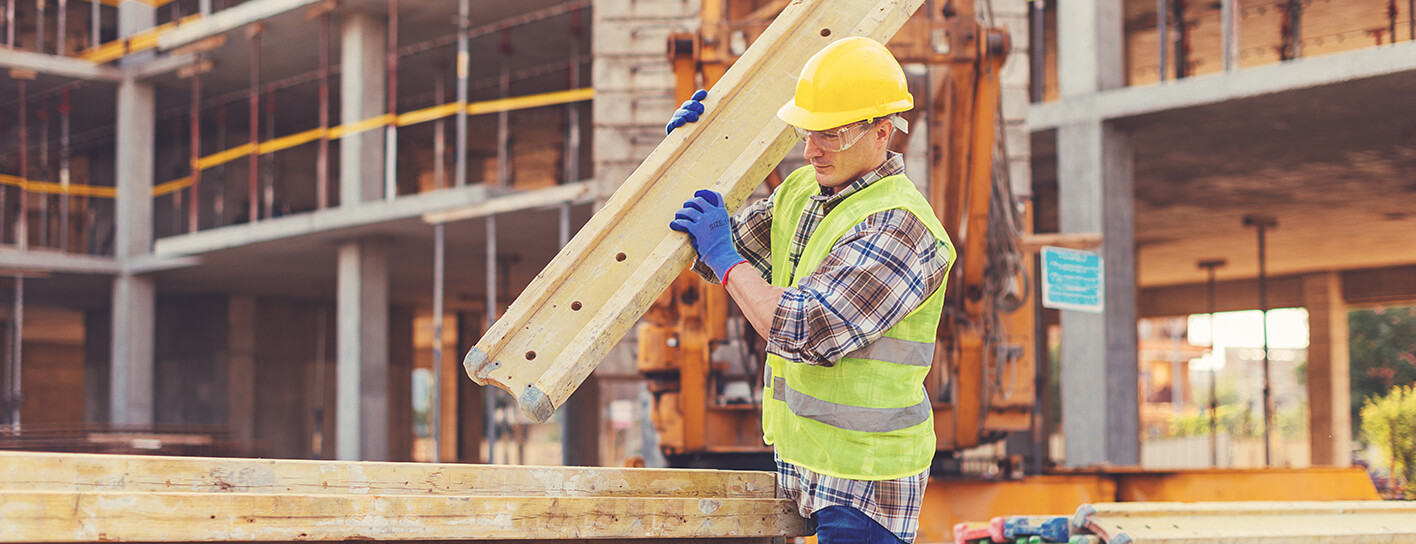 Employee wearing a high vis and a hard hat performing correct manual handling