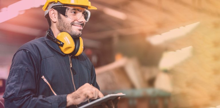 Man taking notes and reporting on health and safety in a factory setting