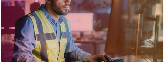 Construction worker using the computer for compliance tasks.