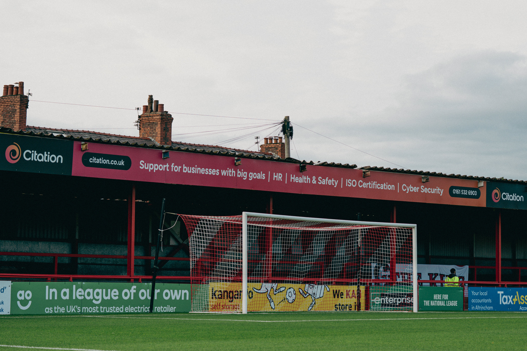 Picture of the Golf Road Stand at Altrincham FC with Citation's new branding. Stand image says 'Supporting businesses with big goals'